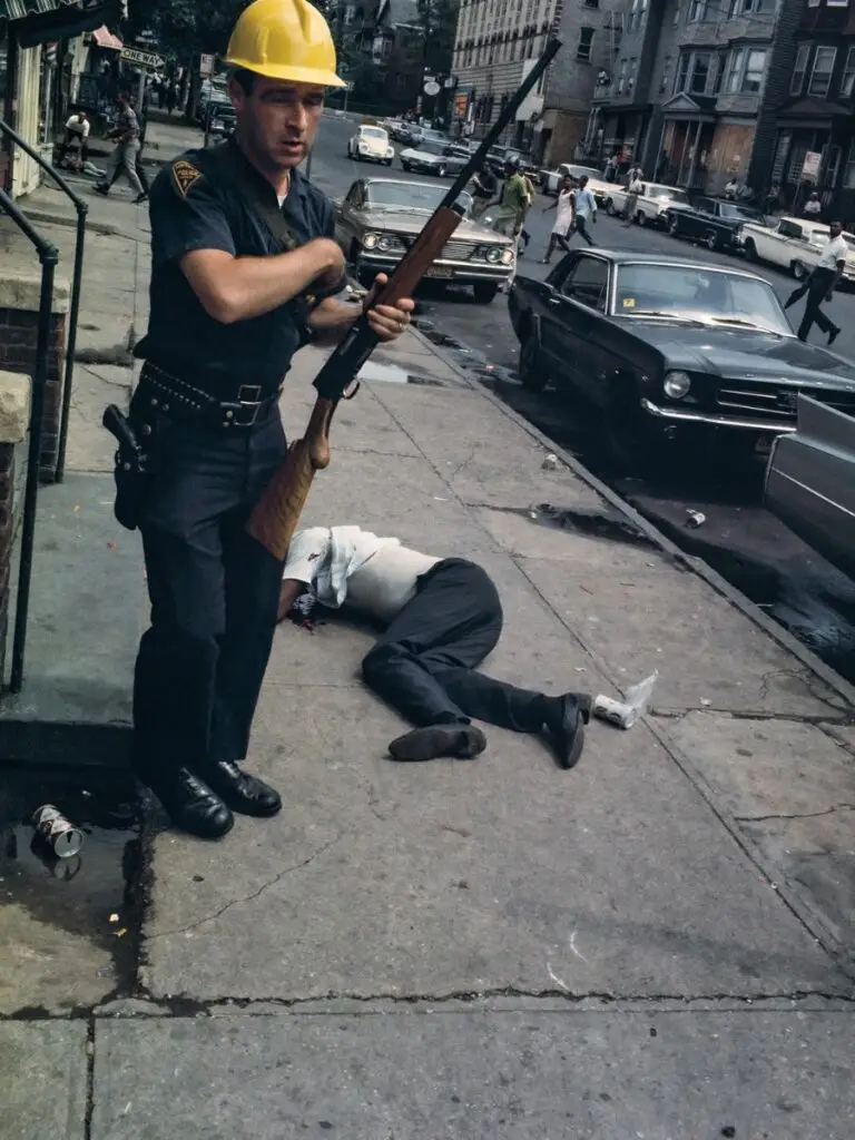 Bud Lee - Far Out Magazine - Police Officer stands over the body of Billy Furr