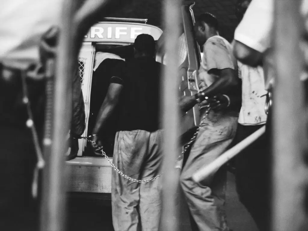 Bud Lee - Far Out Magazine - Chained arrestee