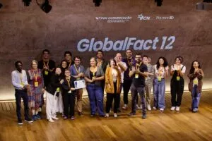 Un grupo numeroso se encuentra en un escenario durante la conferencia GlobalFact 12.' width='786' height='524' title=