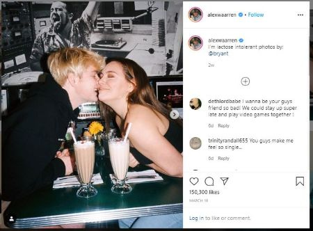   Alex avec sa petite amie Kouvr embrassant le geste alors qu'ils sont assis sur la table avec du café devant eux