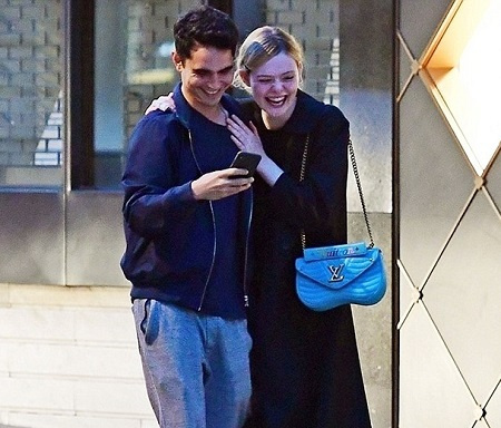 Elle Fanning e Max Minghella caminhando juntos esfregando os ombros em Londres