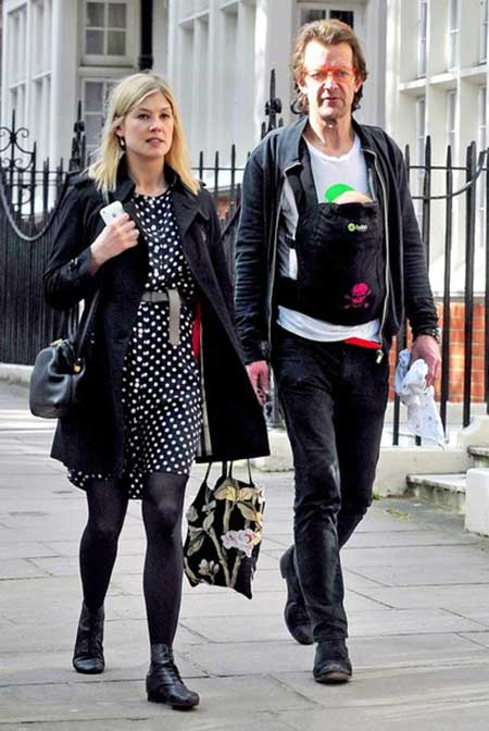   Robie Uniacke e sua parceira Rosamund Pike andando pelas ruas