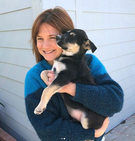Bonnie Wright cargando a su cachorro Ginny en sus brazos