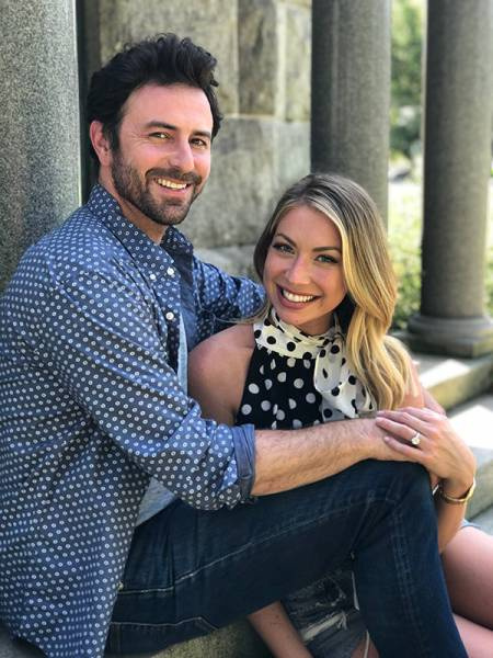 Stassi assis sur Beau's legs as she shows her engagement ring.