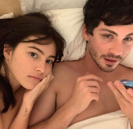 Logan y su novia Ana haciendo clic en una foto mientras están en la cama.