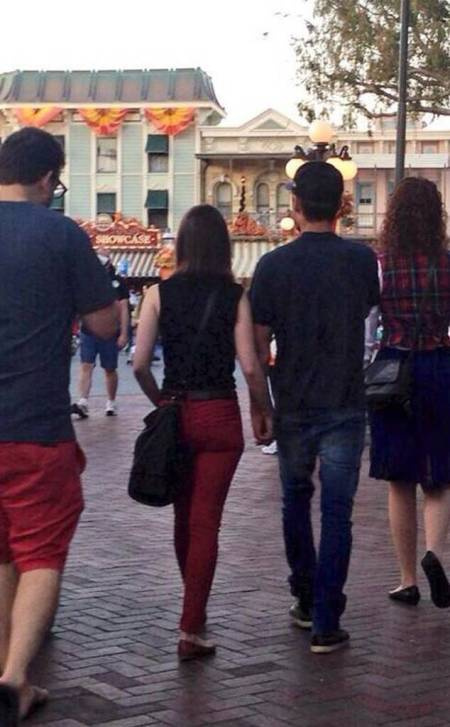 Lily Collins y Zac Effron tomados de la mano en Disneylandia.
