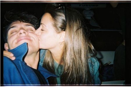 Casey Cott recibiendo un beso en la mejilla de una chica.