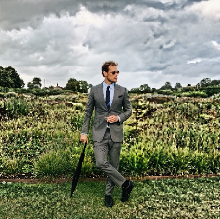 Caitriona Balfe's husband Sam Heughan on TV taking an umbrella on the right hand and a drink on the left hand