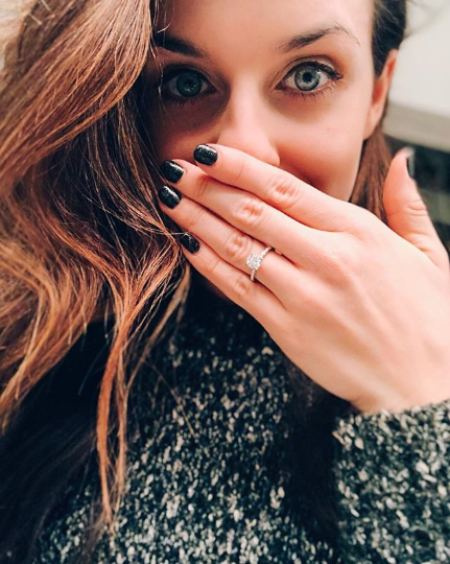   Bridgette mostrando su anillo de compromiso.