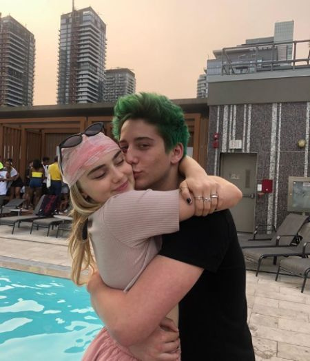 Meg Donnelly e Milo Manheim se beijando na piscina.