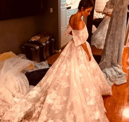   Maria mostra il suo abito da sposa bianco personalizzato a velo lungo.