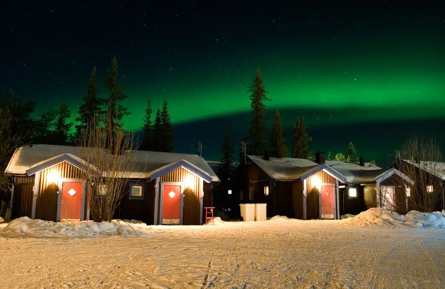 Northern lights over cabins at the Ice hotel in Jukkasjärvi, Sweden